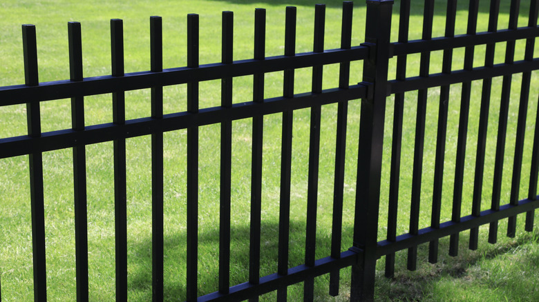 Open-slat fence made of black metal on  grass