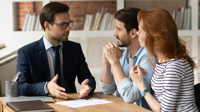 Couple speaking with man