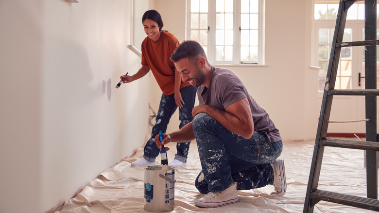 Couple painting a wall