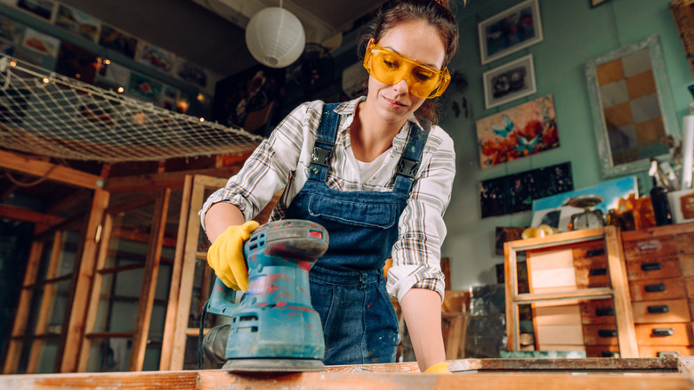 woman using orbital sander