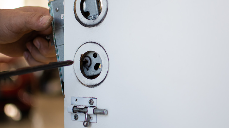 Person removing deadbolt