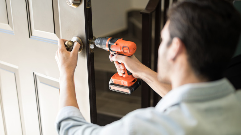 Man using drill on door