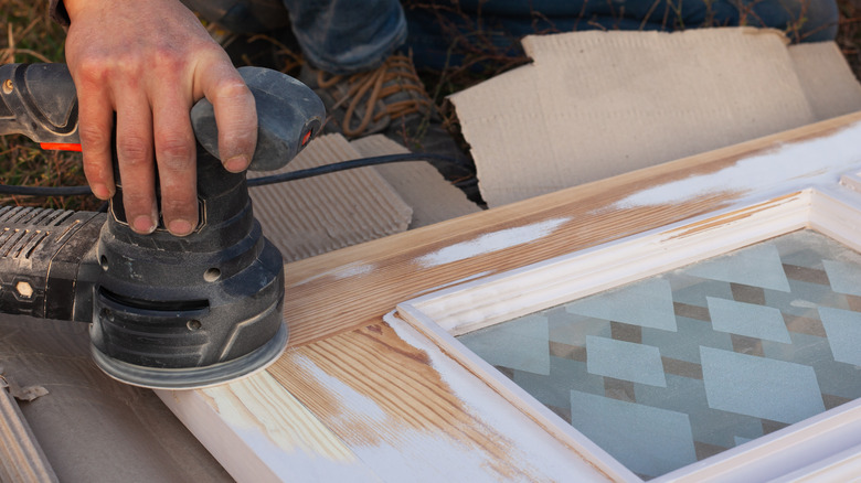 Person's hand holding orbital sander 