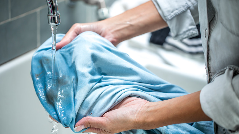 Rinsing shirt under running water 