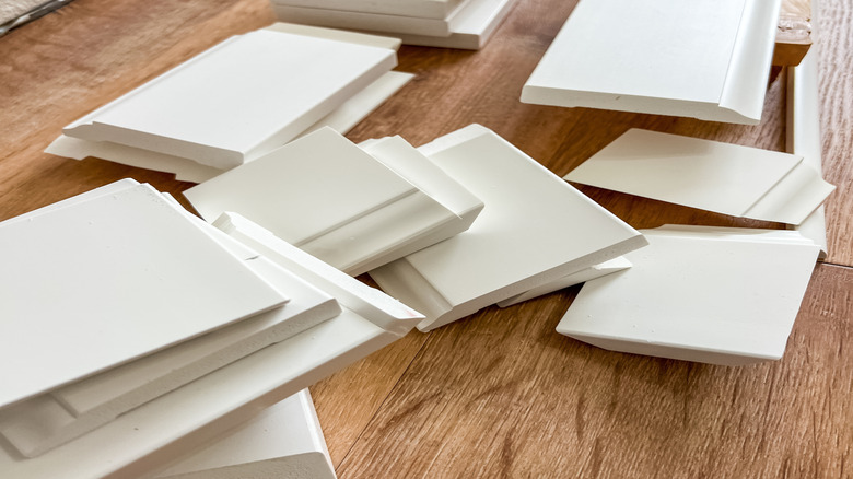 Assorted pile of white baseboards.