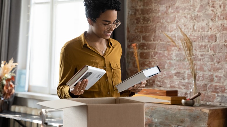 woman placing books in box