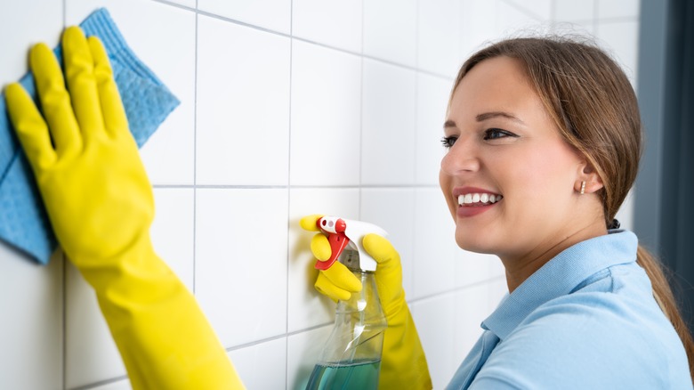 Woman cleans tiles with rag