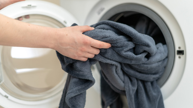 blanket being placed into washer