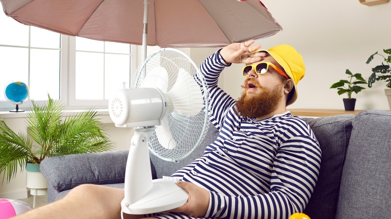 Man on couch with fan