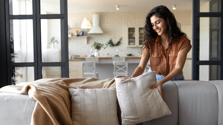 woman adding comfort to couch