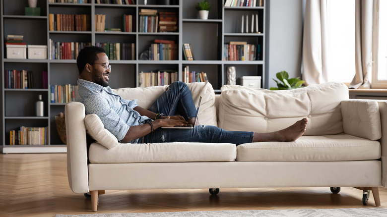 man working from comfy couch