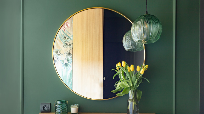 decorative mirror on green wall