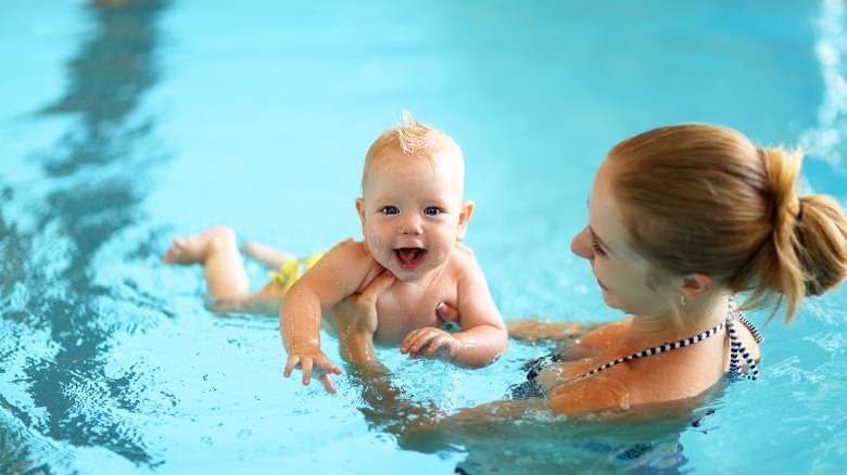 Mother teaching infant to swim 