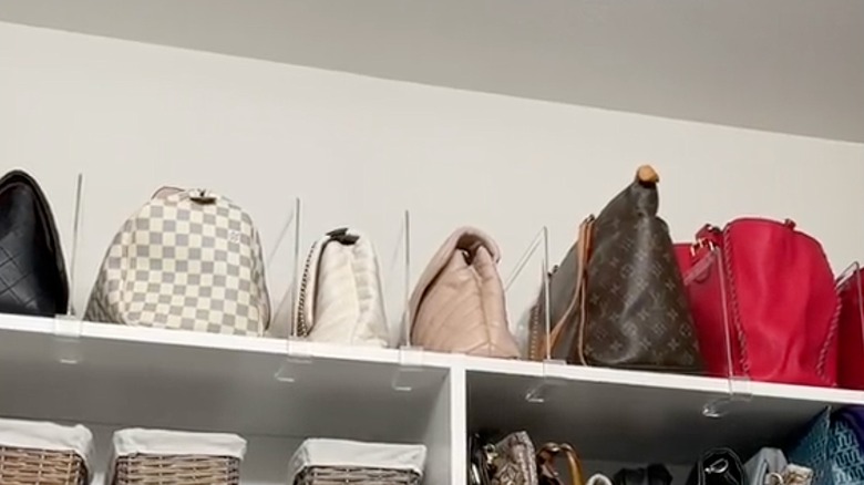 Shelf with dividers separating handbags