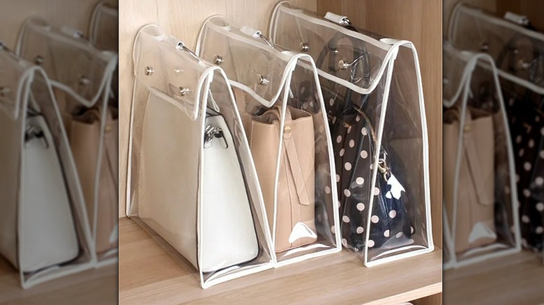 Handbags hanging from a rack in clear bags