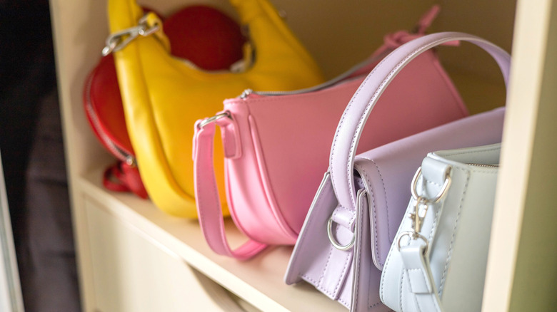 Colorful purses lined up on a shelf