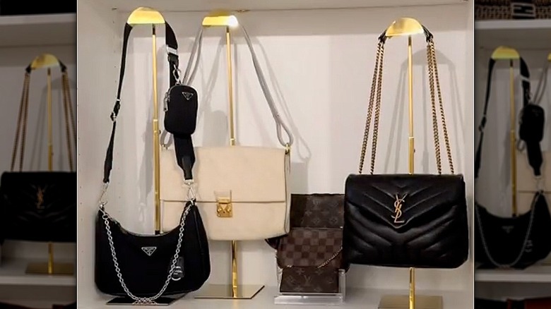 A bookshelf with handbags hanging from a stand