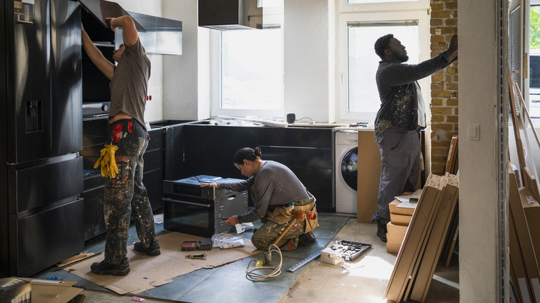 Three contractors renovating a kitchen