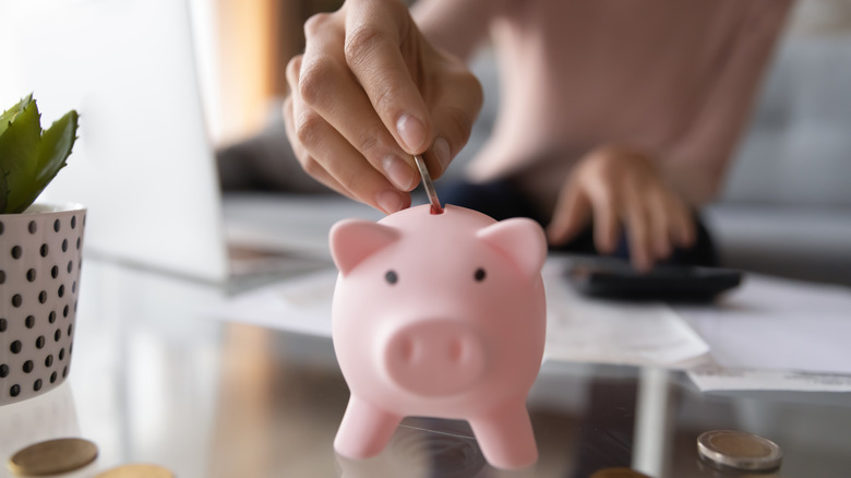 putting coins in piggy bank