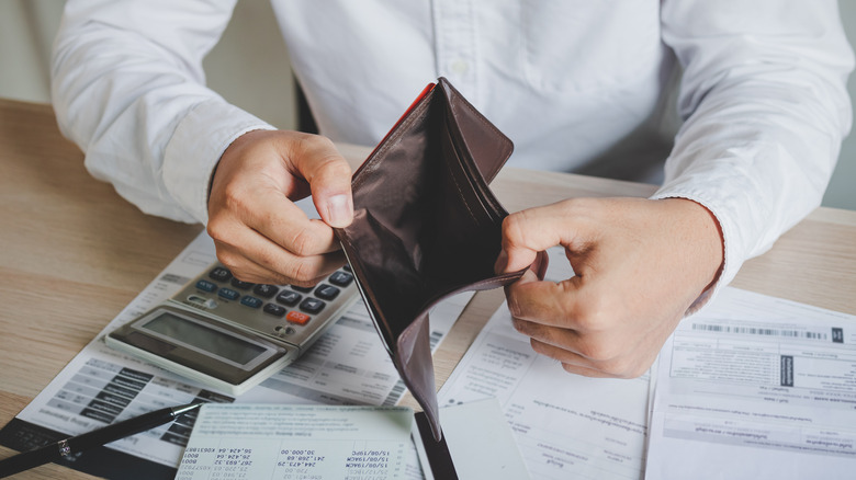 man holding open empty wallet