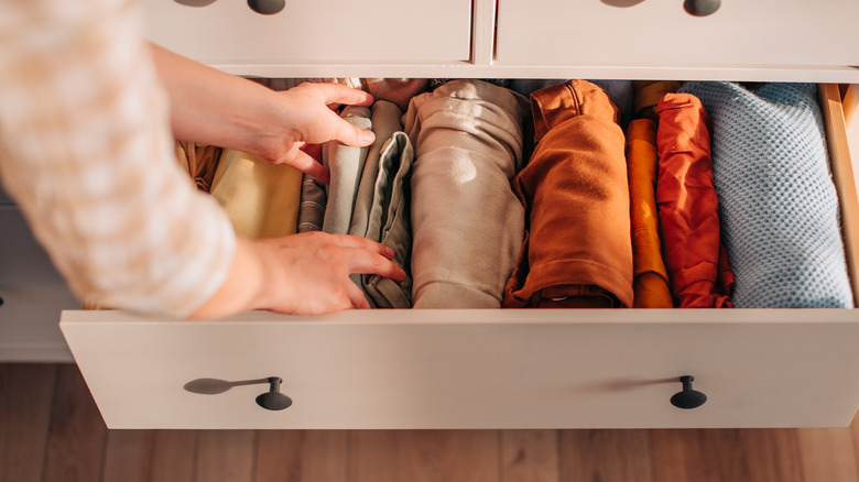 Person reaching into clothing drawer