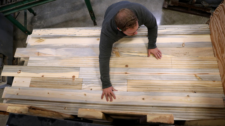 person with pine flooring planks