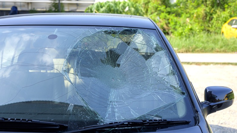 broken car windshield in front of driver's seat