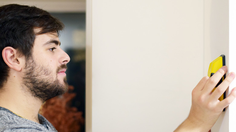 Person holding stud finder 