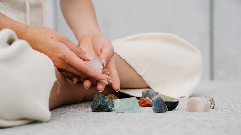 Person sitting with healing crystals