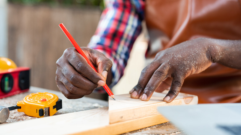 Carpenter measuring on wood