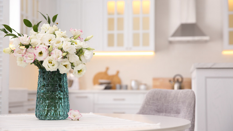 Fresh flowers in a vase on a kitchen table