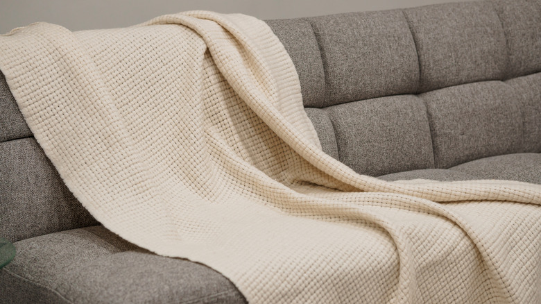 White throw blanket on a gray sofa