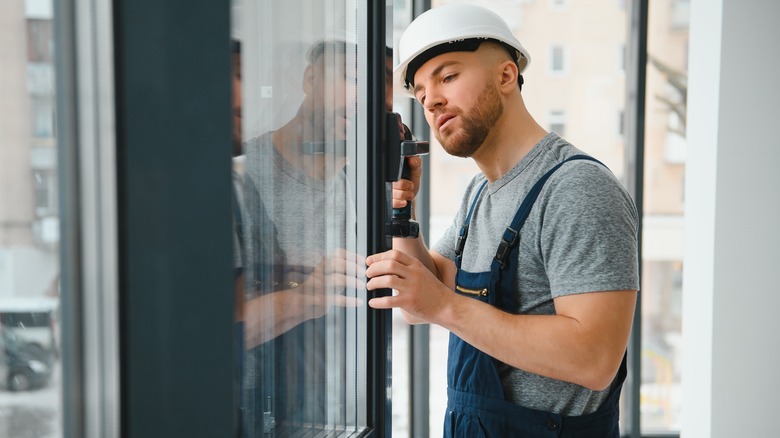 man measuring a window