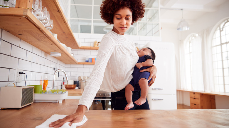 woman with baby cleaning