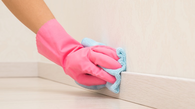 Wiping baseboards with cloth