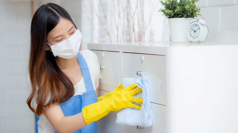 person cleaning with mask and gloves