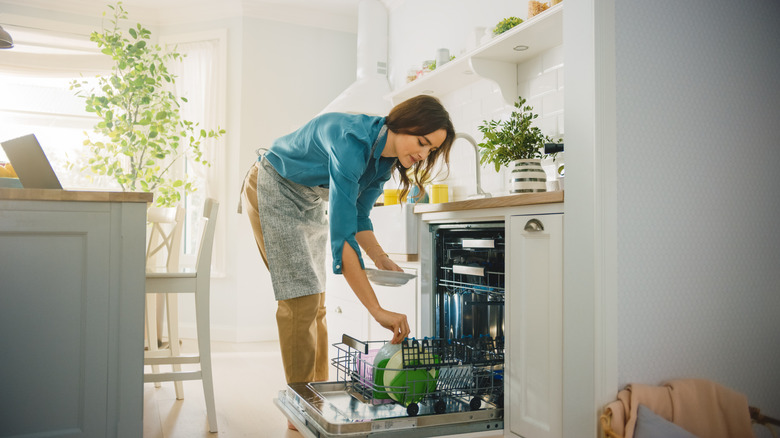 Woman loading dishwasher