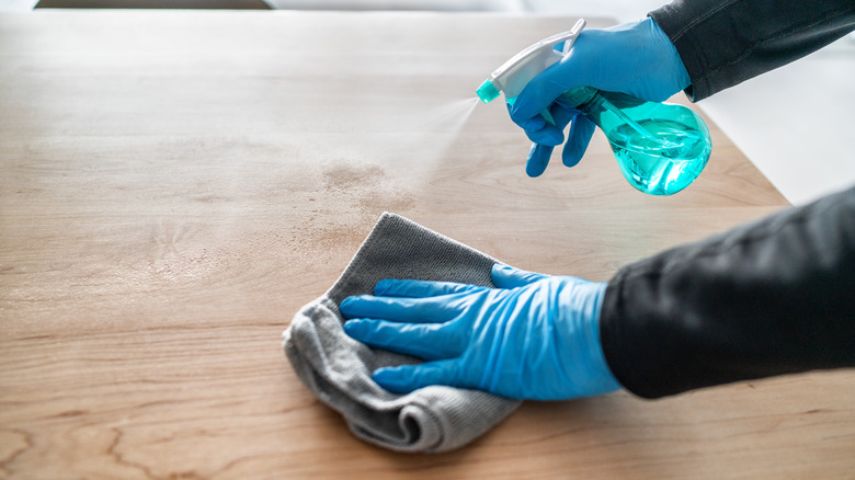 Person cleaning wood table