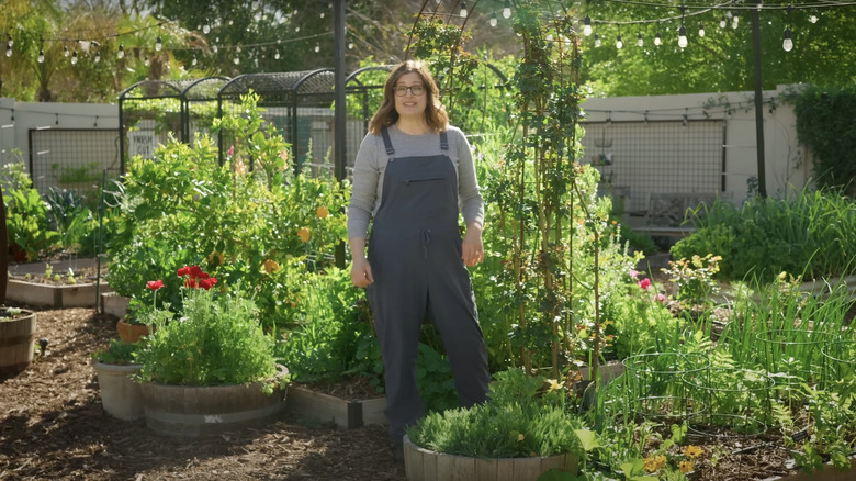 woman standing in a large outdoor container garden