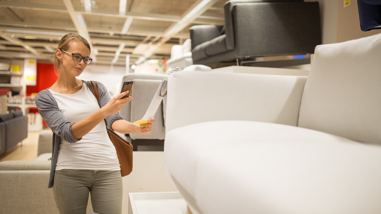 woman photographing price tag of new couch