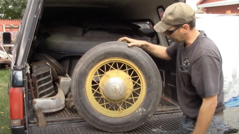 man examining used car tire