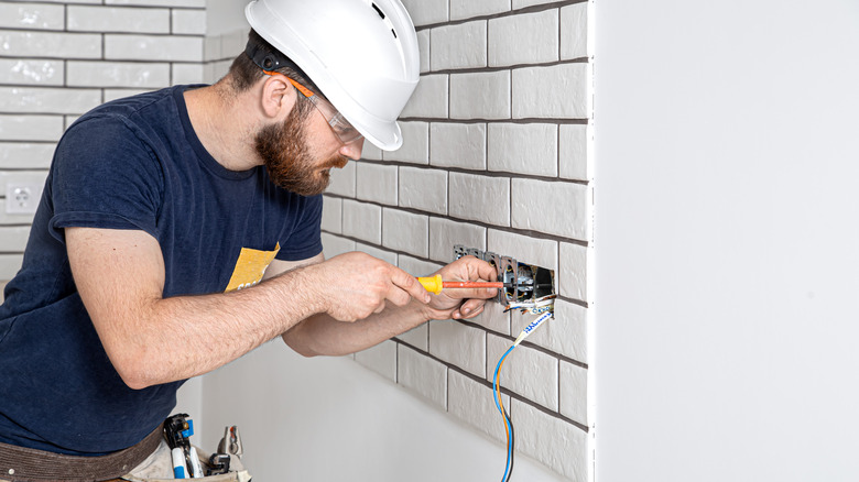 electrician rewiring outlet