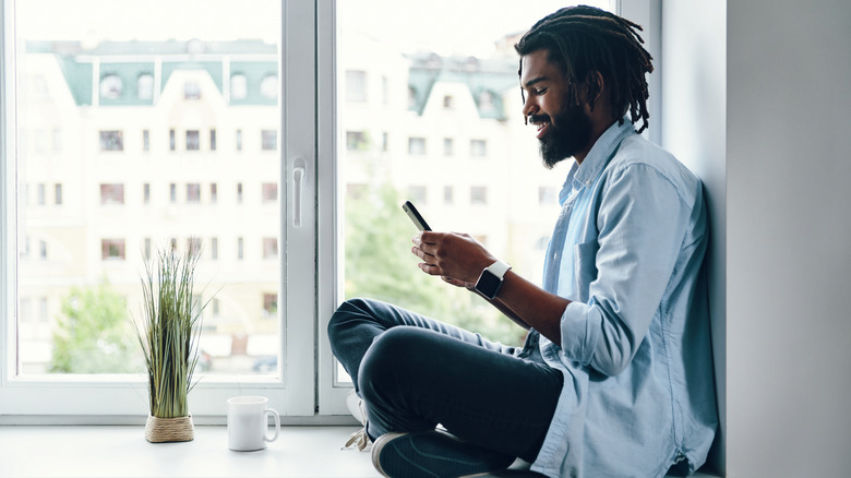 man sitting in windowsill