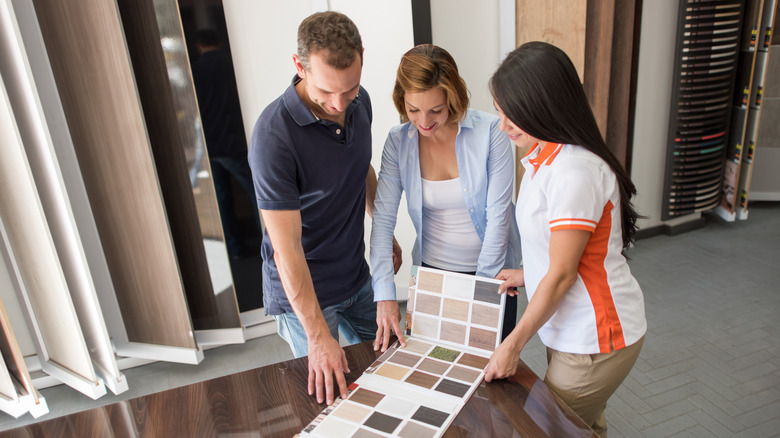 Three people looking at tile samples