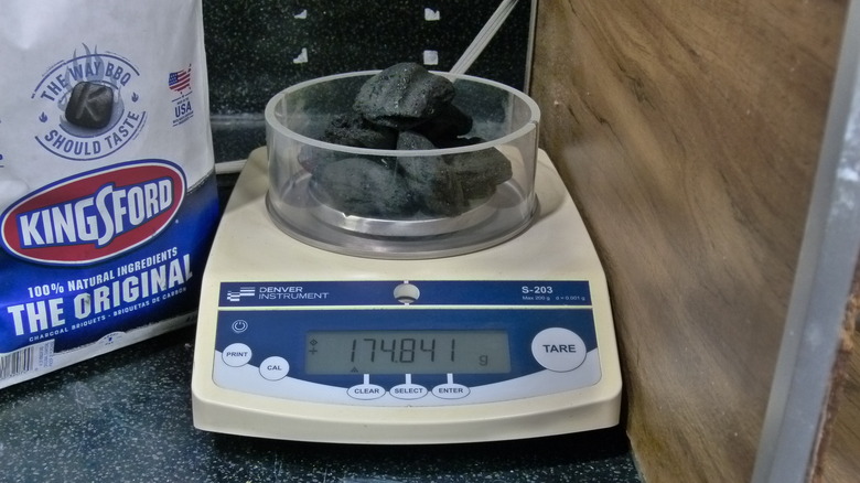 Weighing charcoal in scientific scale