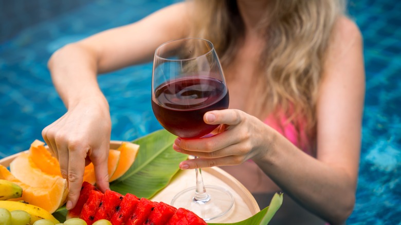 Woman in pool eating fruit