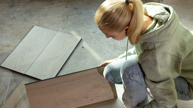 Woman looking at vinyl floor tiles