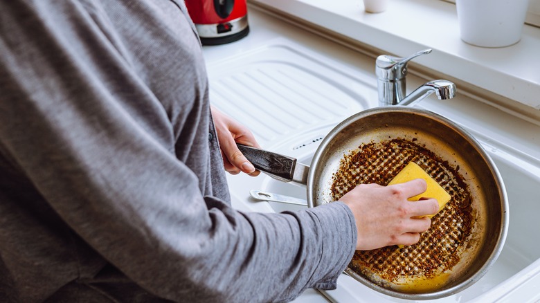 Woman washing dirty pan