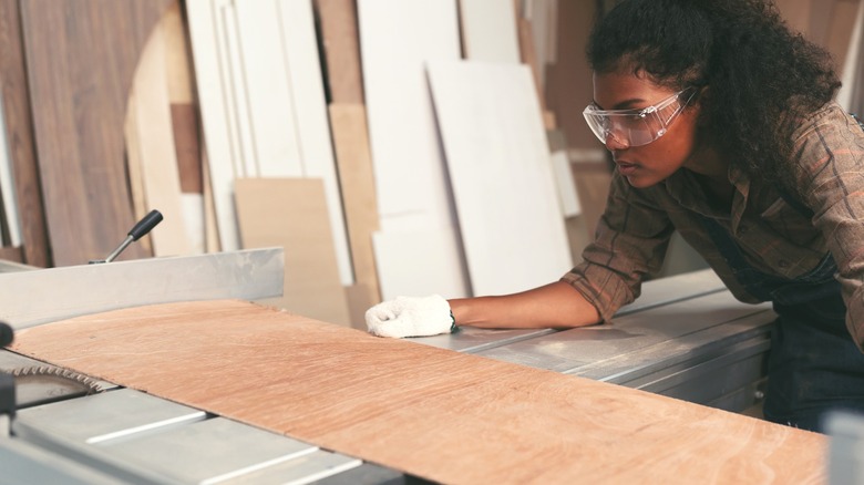 A woman cuts a flexible plywood panel