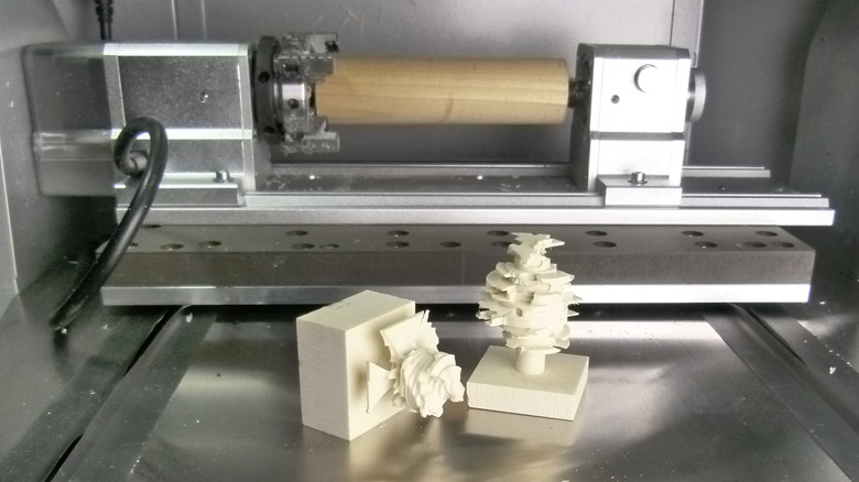 4th-axis rotary module with chucked dowel and pieces of failed milling attempt